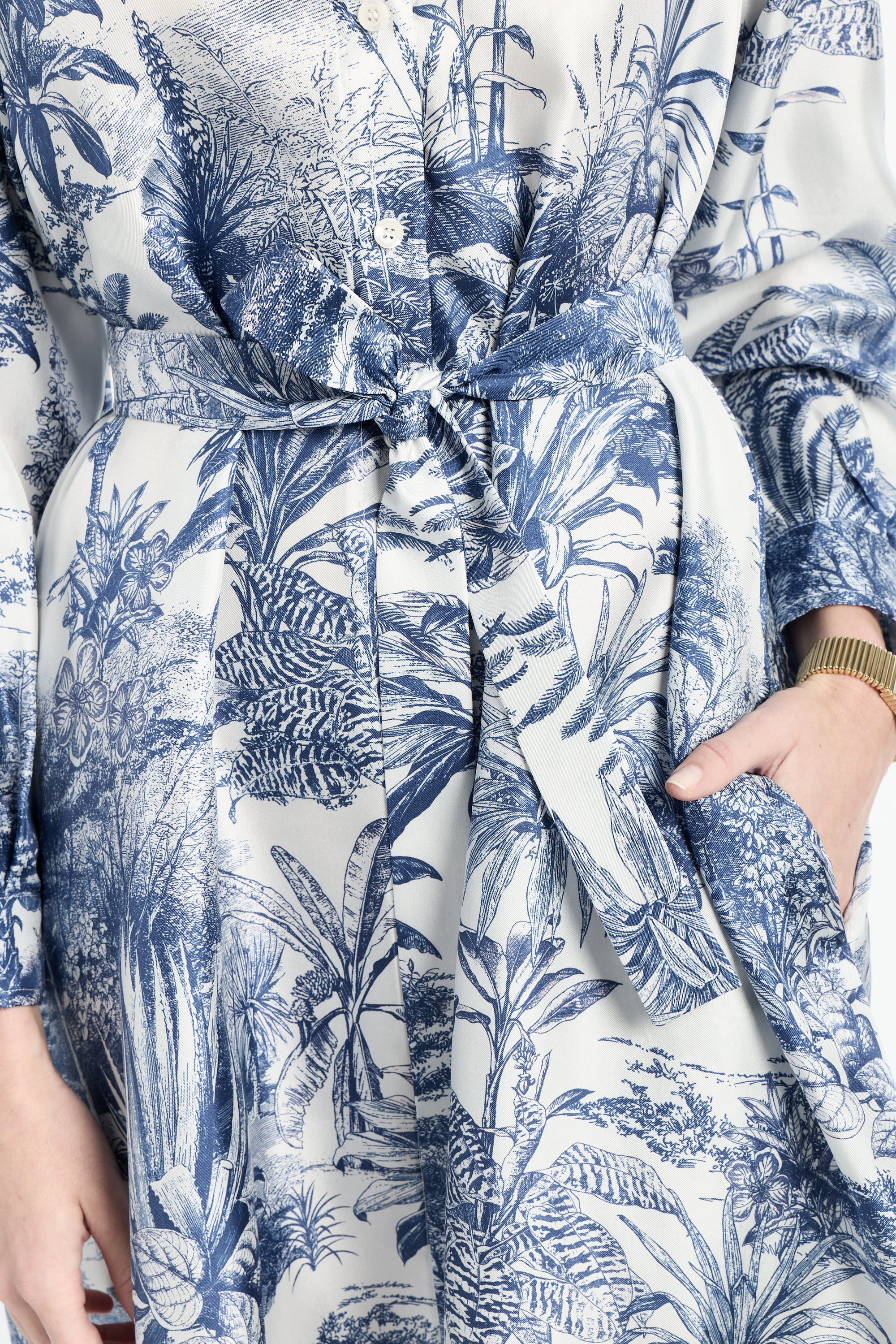 Close-up of a blue and white floral patterned dress with a belt.