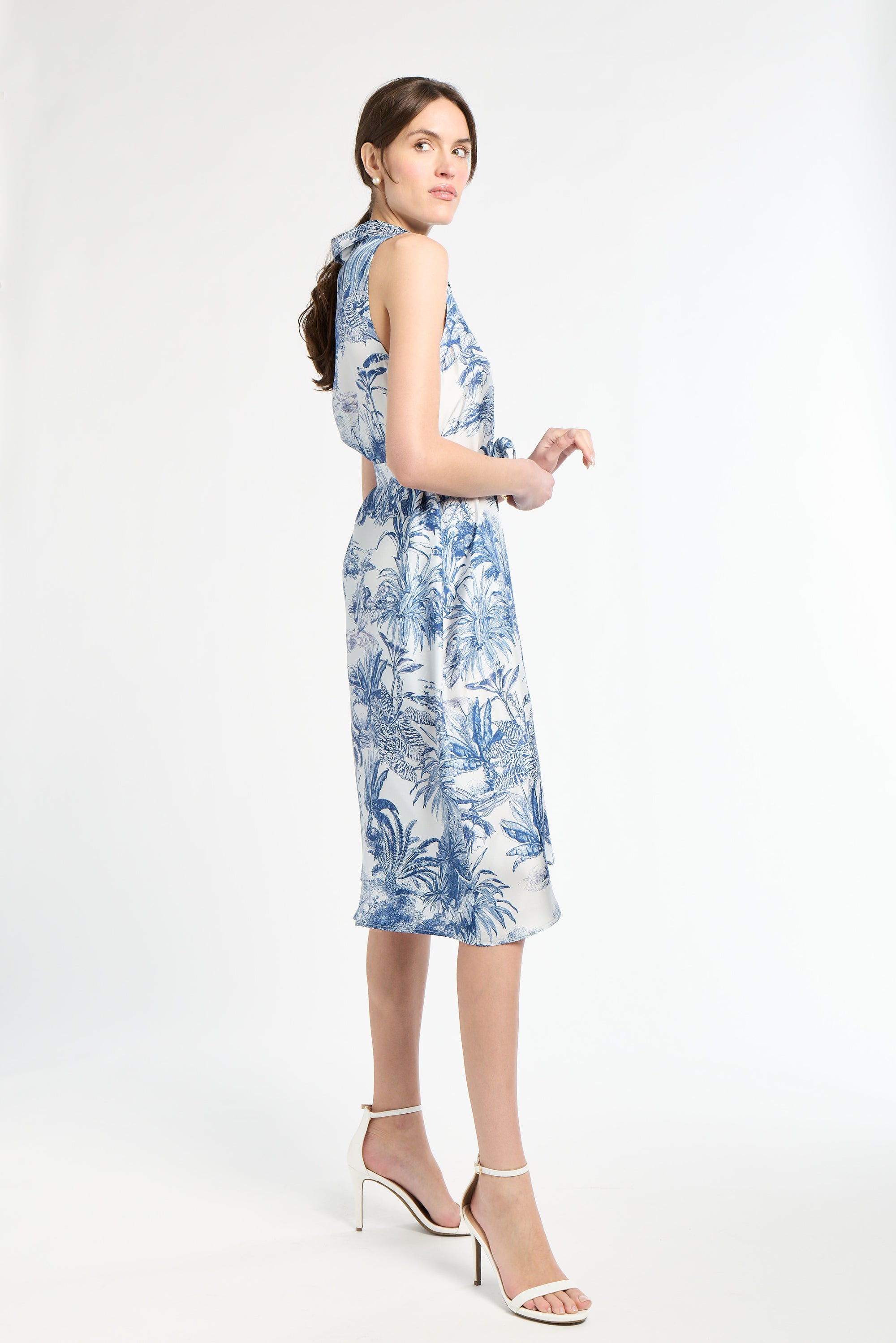woman standing to the side modeling blue patterned midi dress
