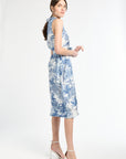 woman standing to the side modeling blue patterned midi dress