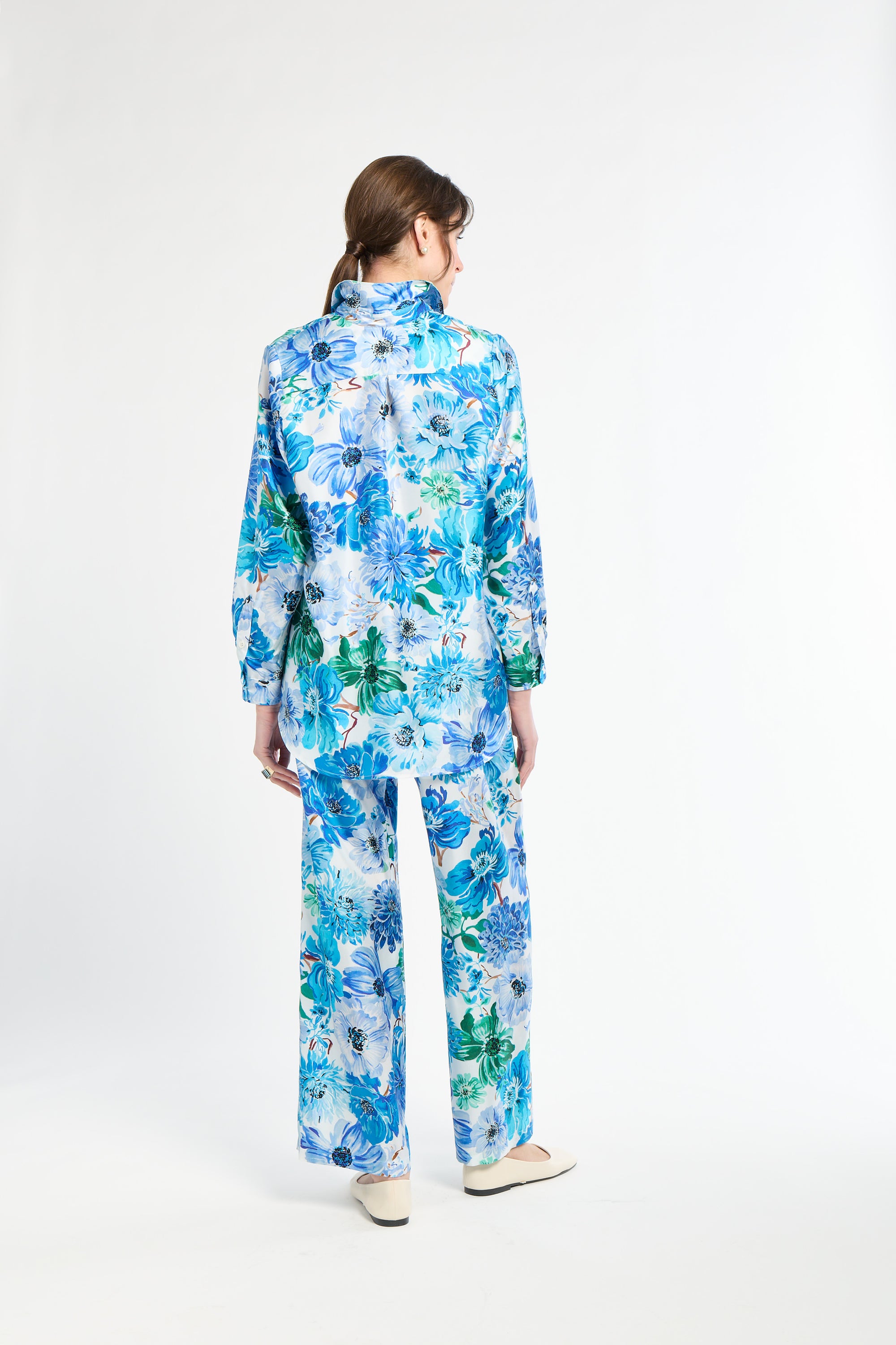 Person wearing a blue floral outfit on a white background