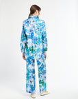 Person wearing a blue floral outfit on a white background