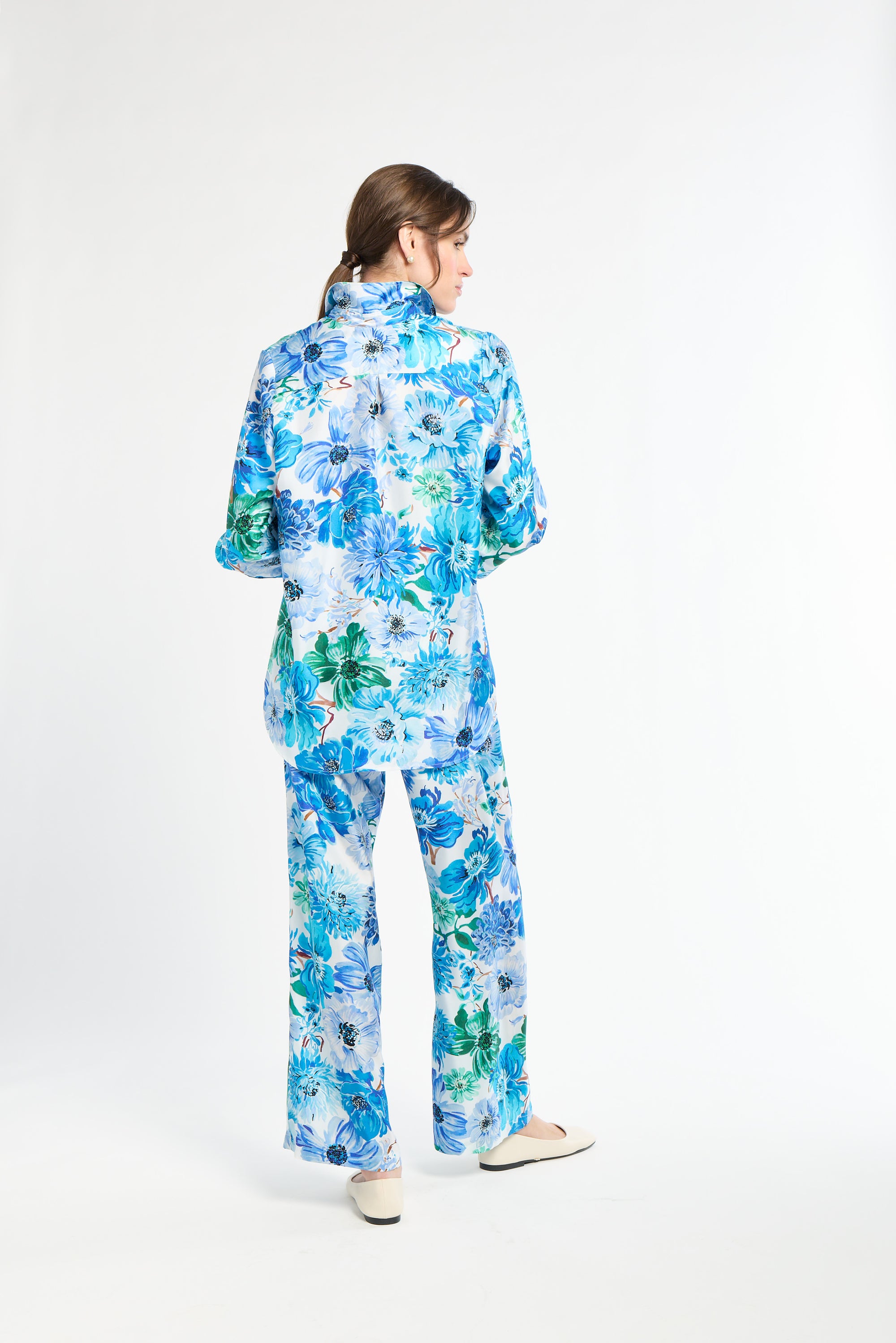 Woman wearing a blue floral outfit on a white background