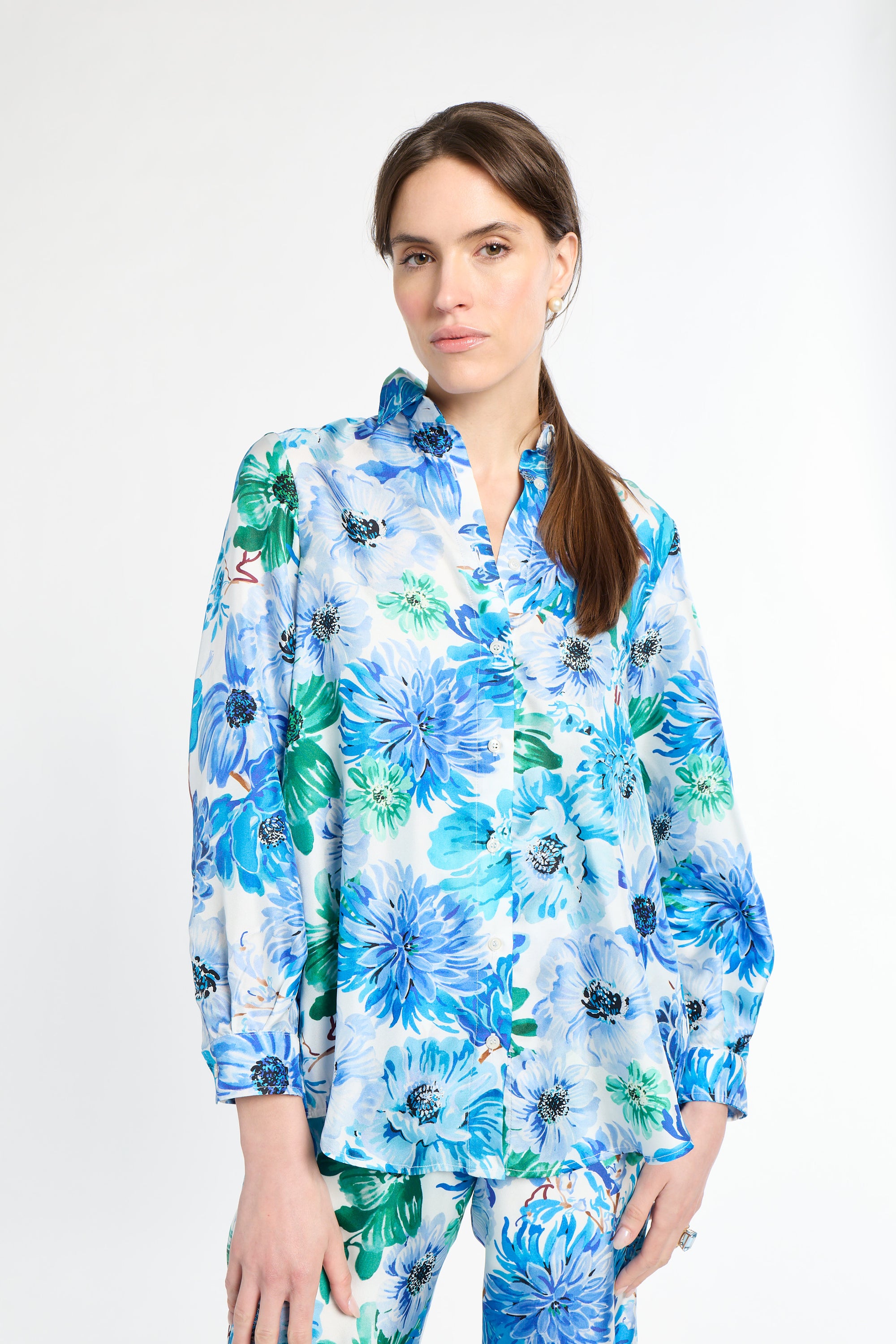 Woman wearing a blue and green silk floral shirt 