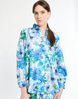 Woman wearing a blue and green silk floral shirt 