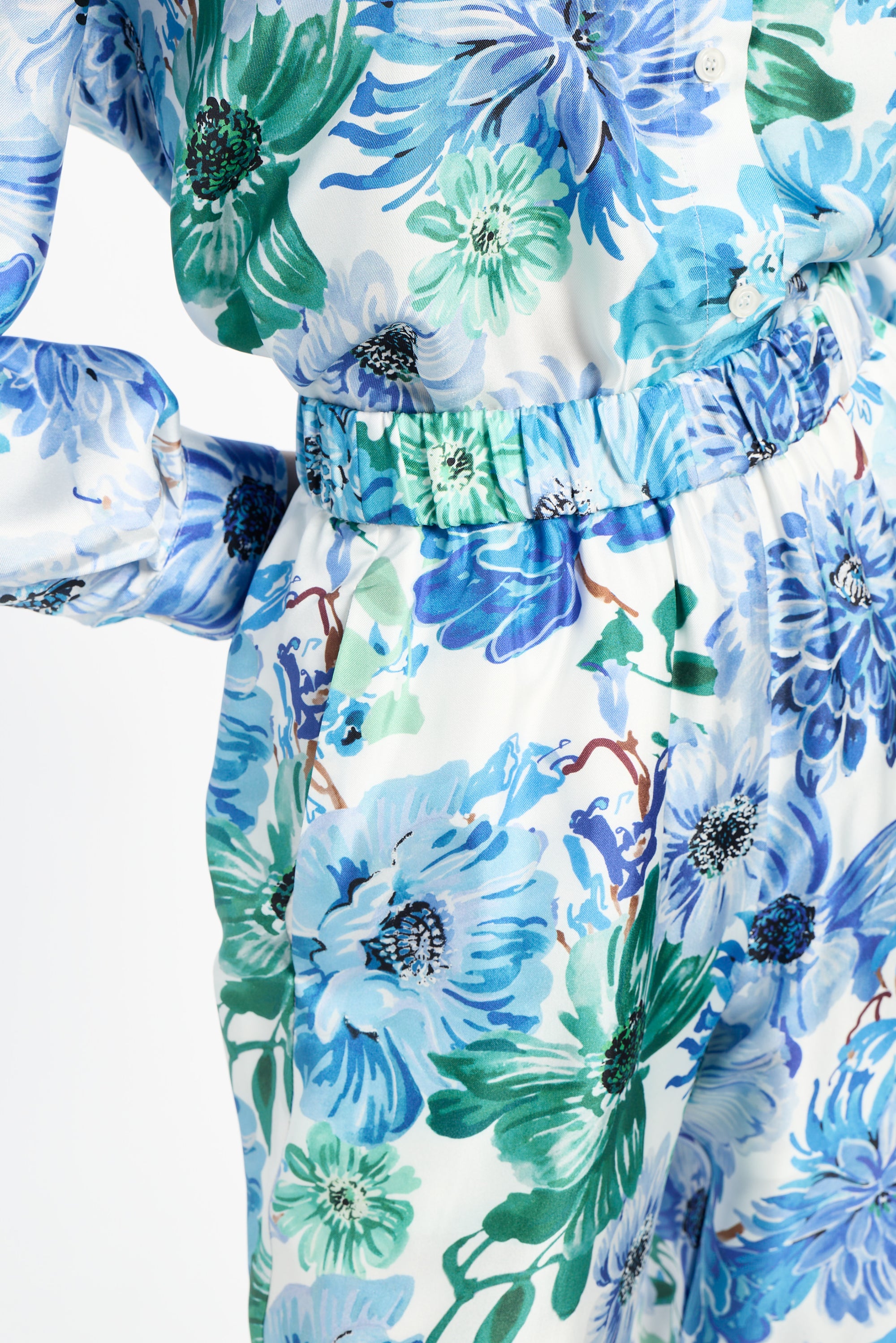 Close-up of a floral shirt and pants with blue and green flowers on a white background