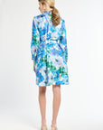 Back of woman wearing a blue and green floral dress on a white background