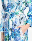 Close up of woman wearing silk shirt dress with blue and green floral pattern