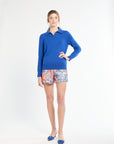 Woman wearing a blue sweater and colorful shorts on a white background