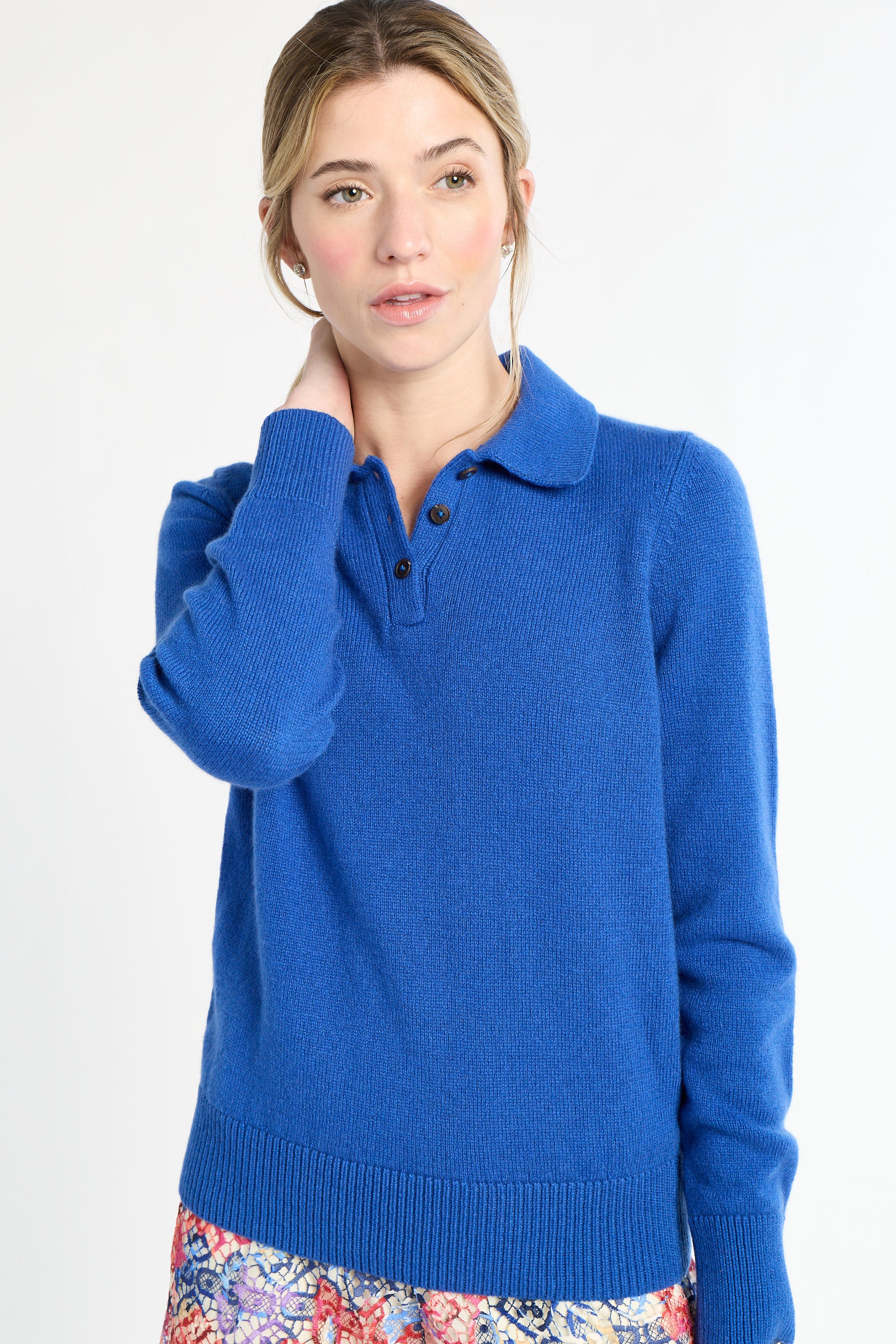 Woman wearing a blue sweater with a collar on a white background