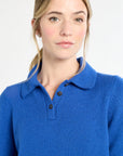 Woman wearing a blue polo shirt against a white background