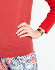 Person wearing a red sweater with a white background
