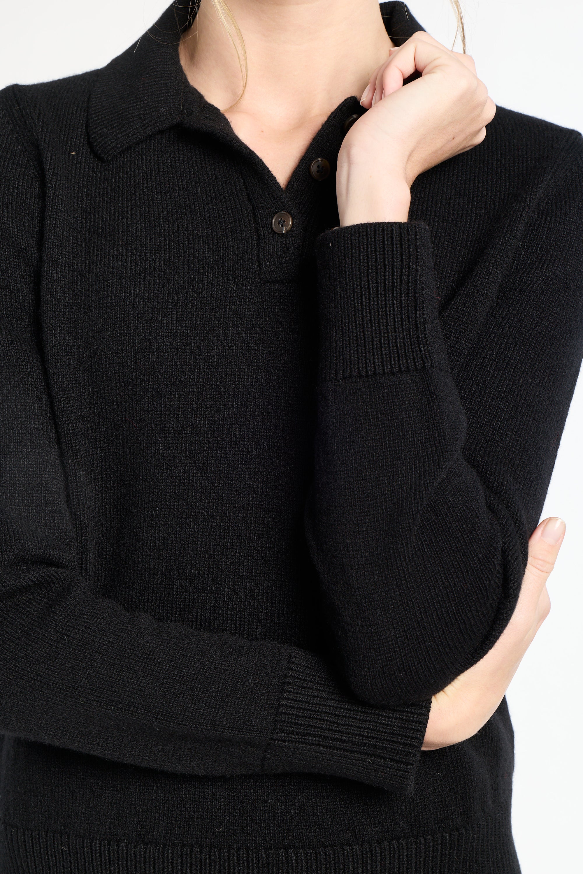 Black sweater worn by a person on a white background