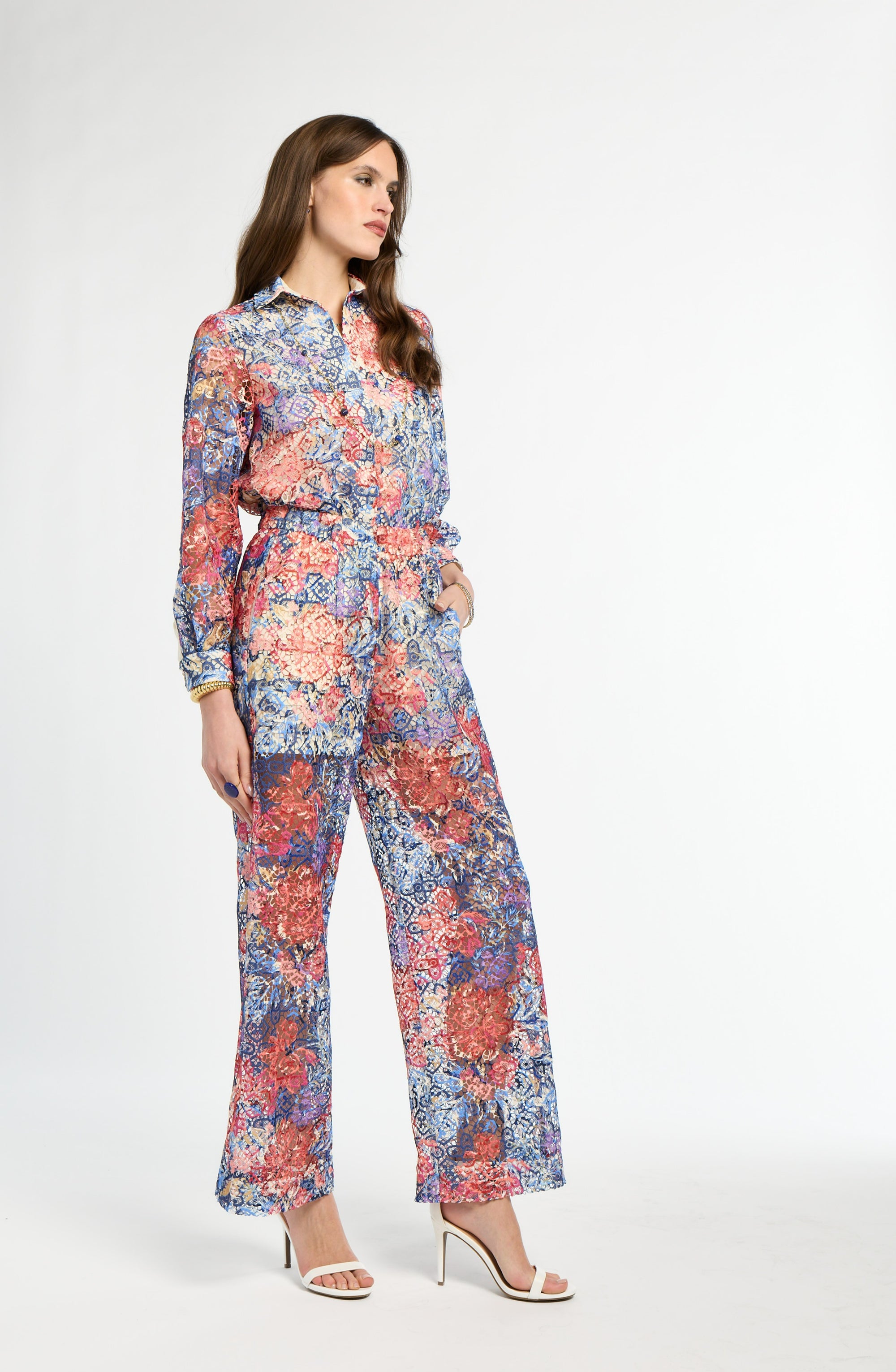 Woman wearing a colorful floral jumpsuit on a white background