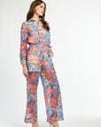 Woman wearing a colorful floral jumpsuit on a white background