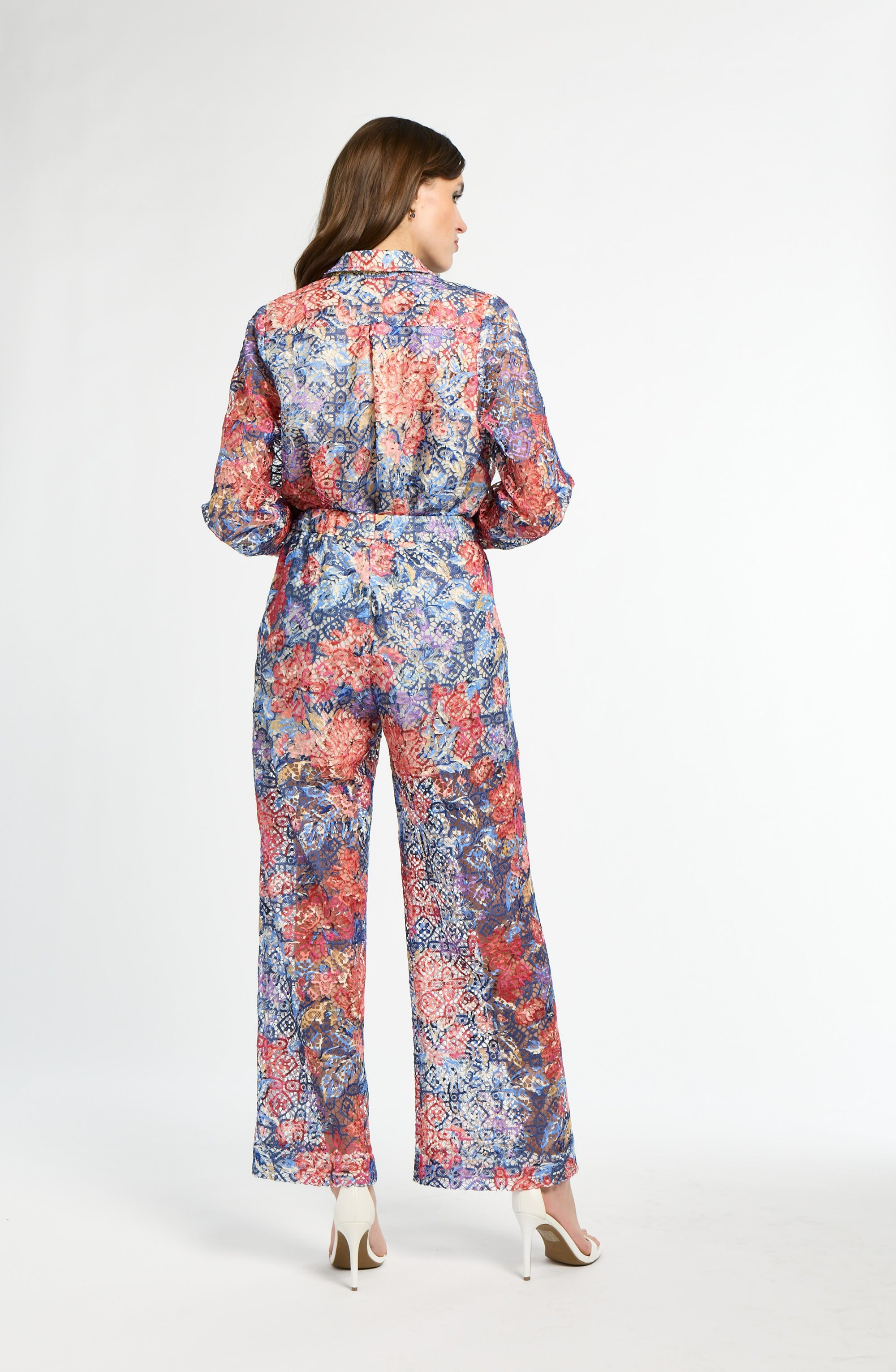 Woman wearing a colorful floral jumpsuit on a white background