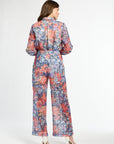 Woman wearing a colorful floral jumpsuit on a white background