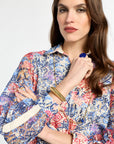 Woman wearing a colorful floral dress against a white background