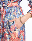 Multicolored floral-patterned dress with a hand pointing to the fabric