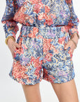 Multicolored floral romper worn by a person on a white background