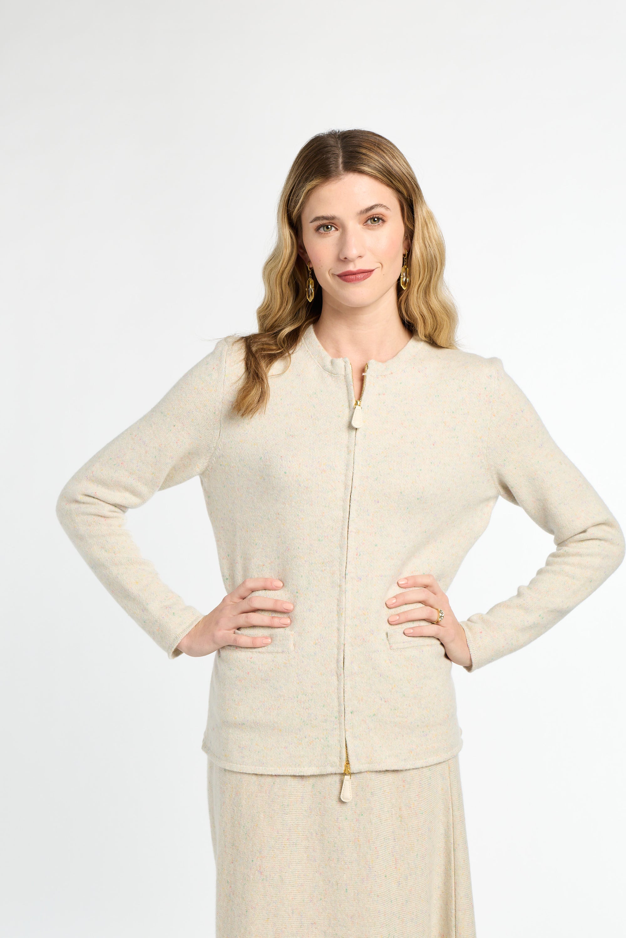 Woman wearing a beige cardigan and skirt set on a white background