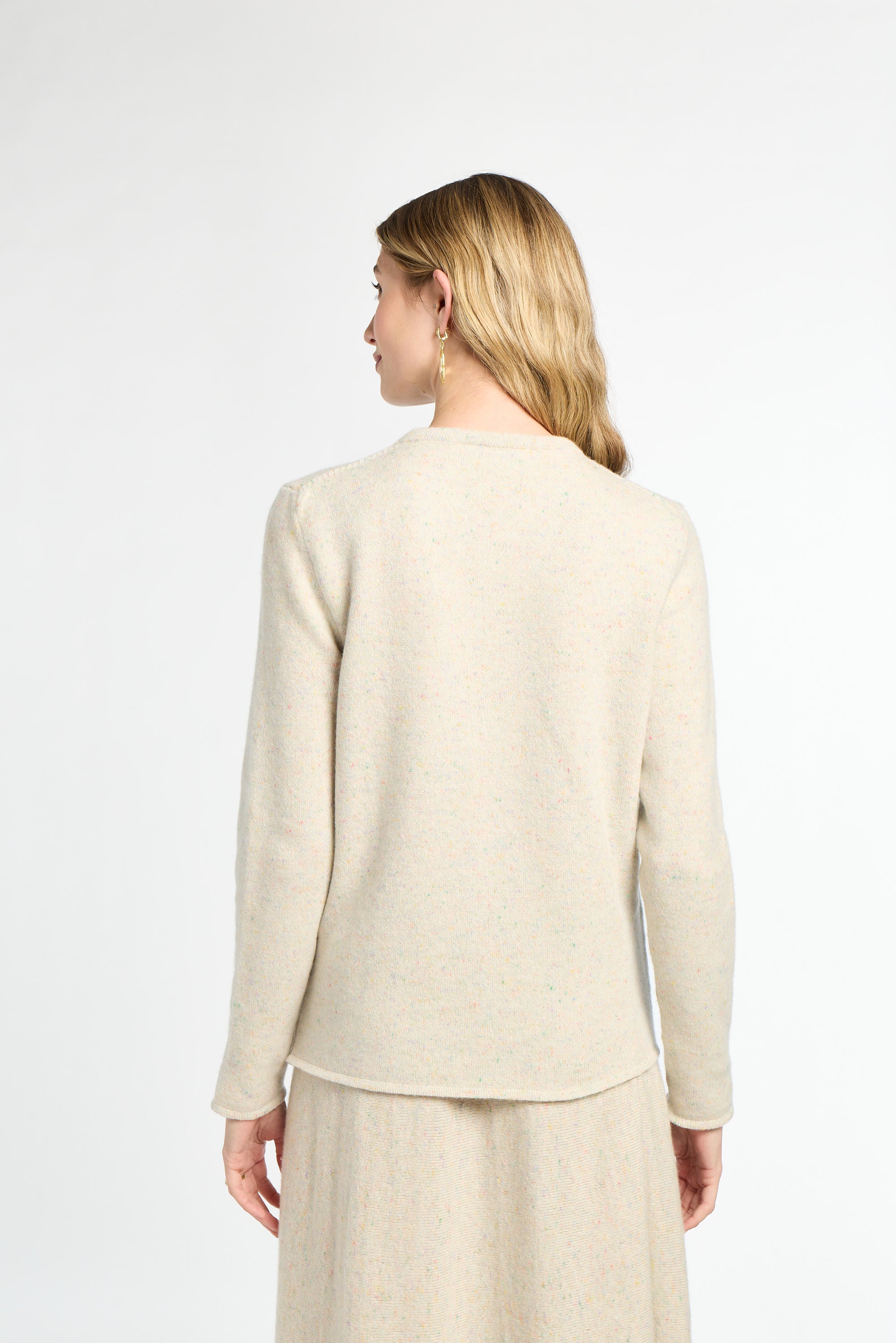 Woman wearing a beige cardigan and pants on a white background