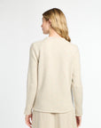 Woman wearing a beige cardigan and pants on a white background