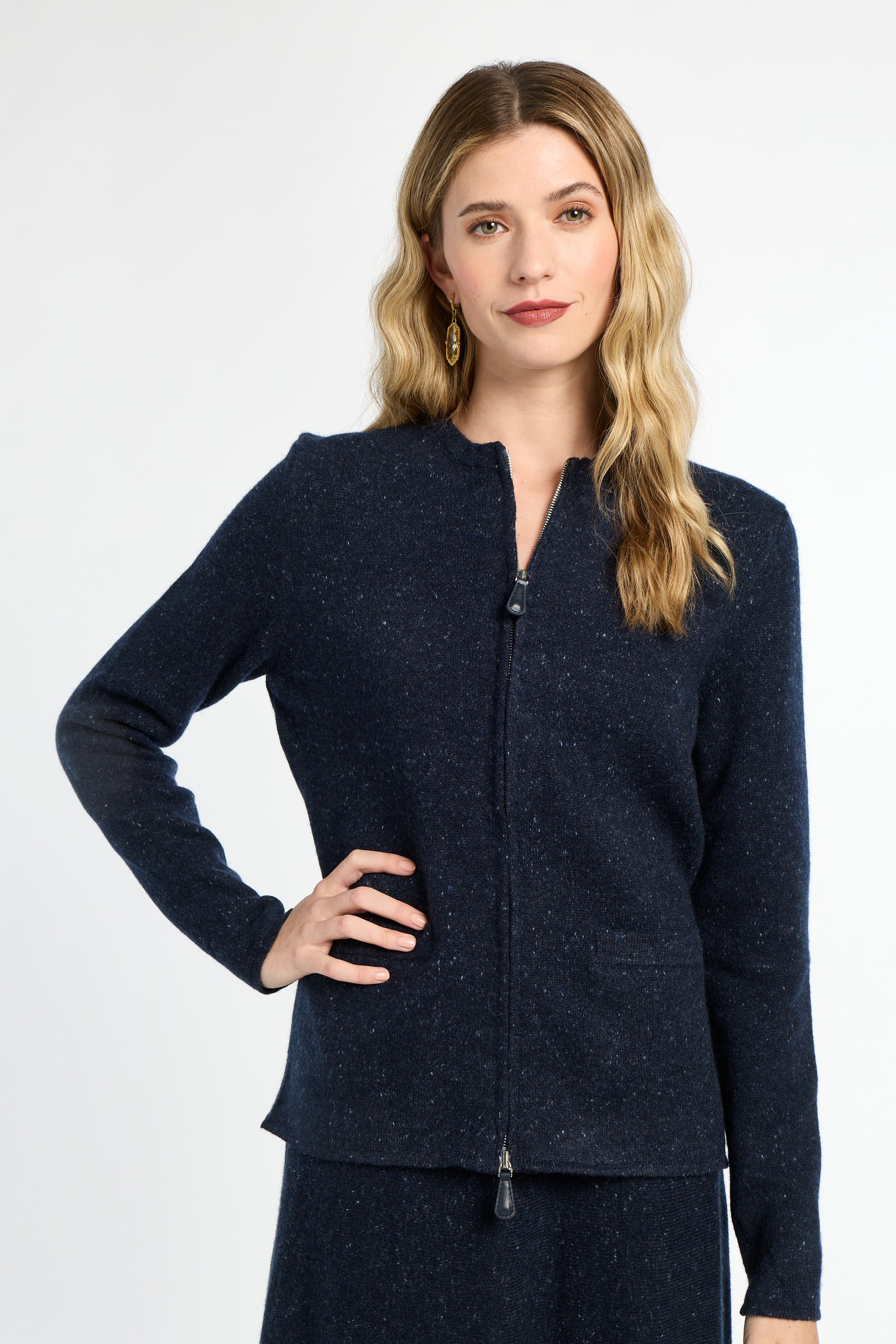 Woman wearing a navy blue zip-up cardigan on a white background