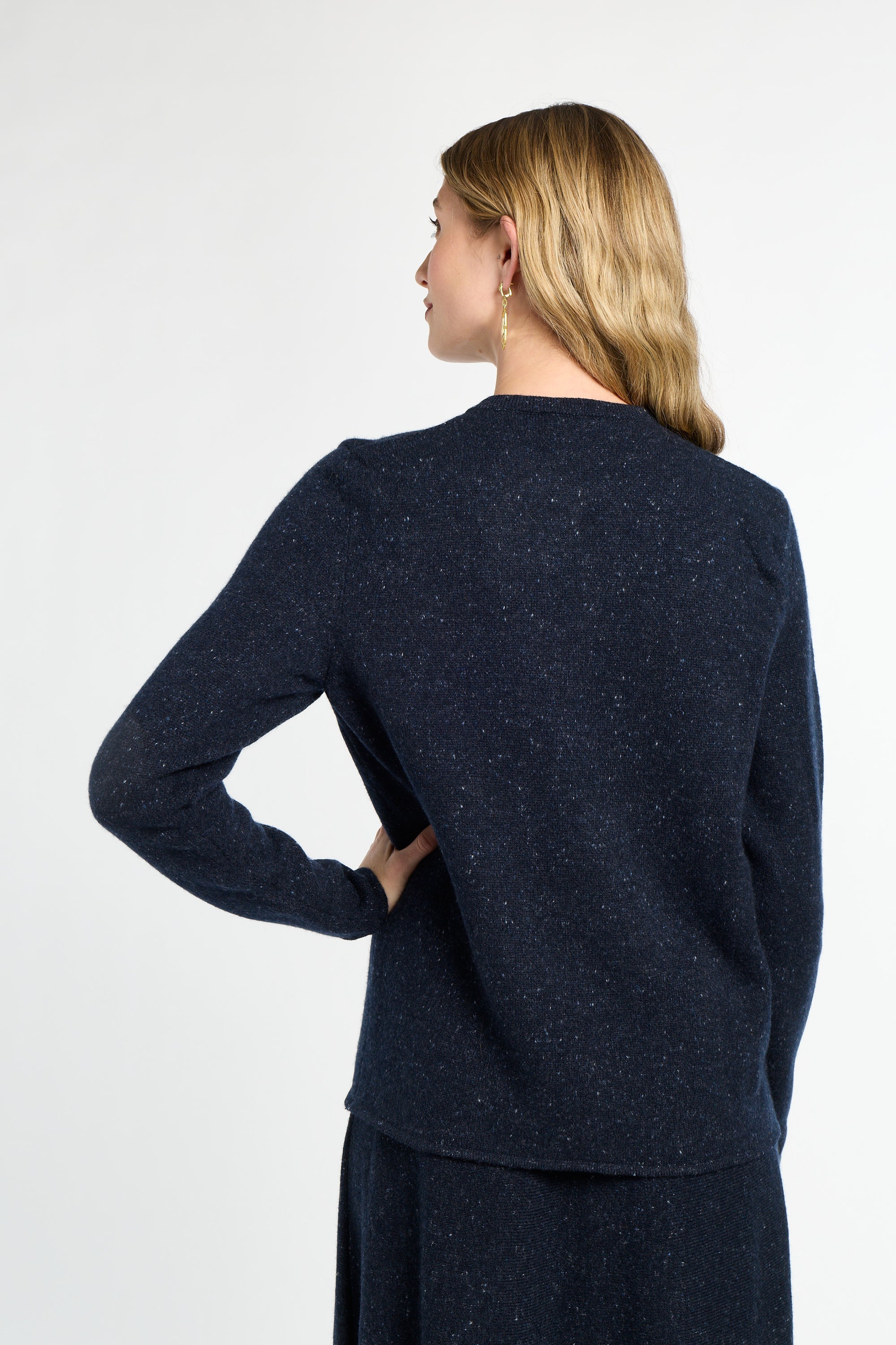 Woman wearing a navy blue sweater against a white background