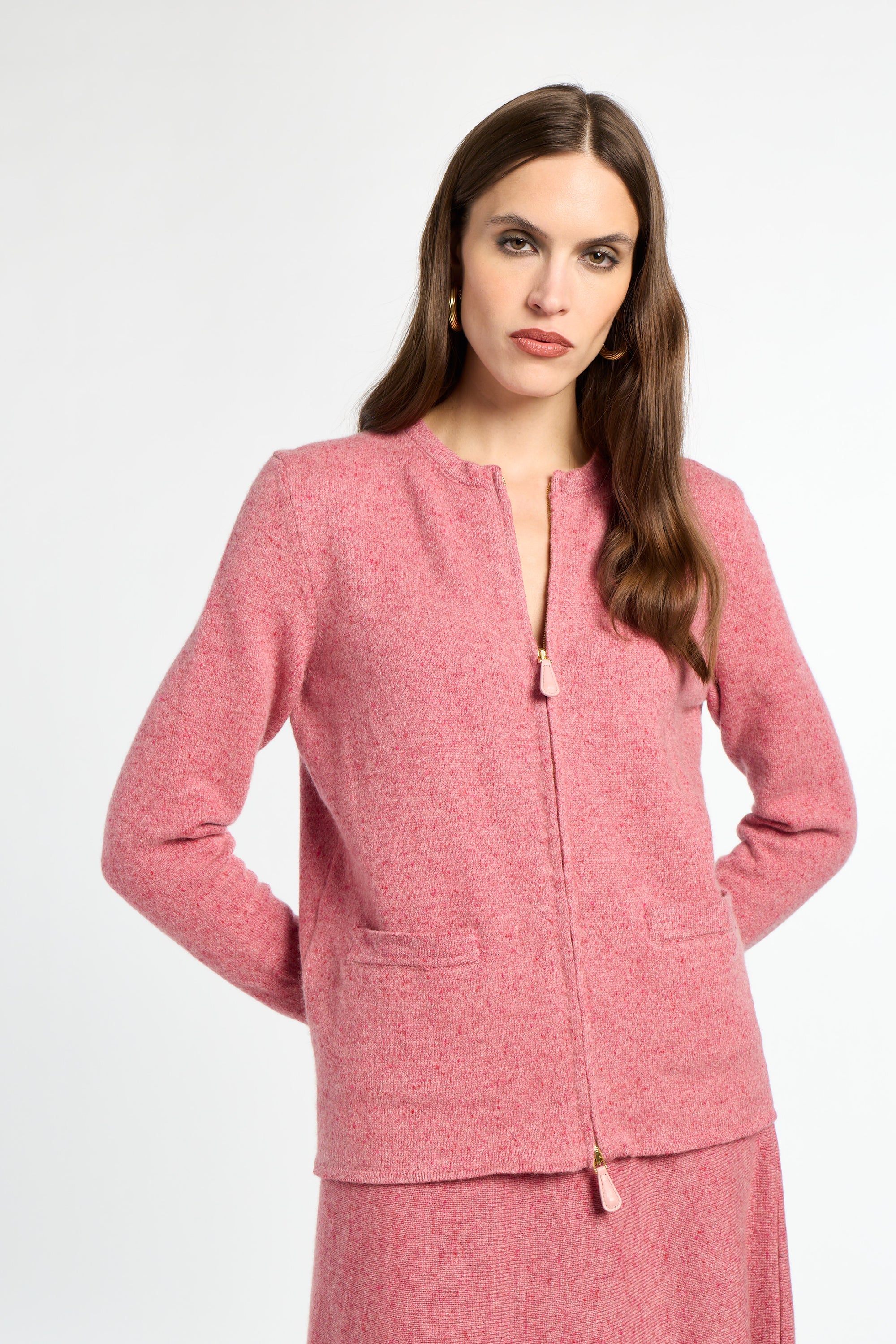 Woman wearing a pink textured jacket and skirt set on a white background