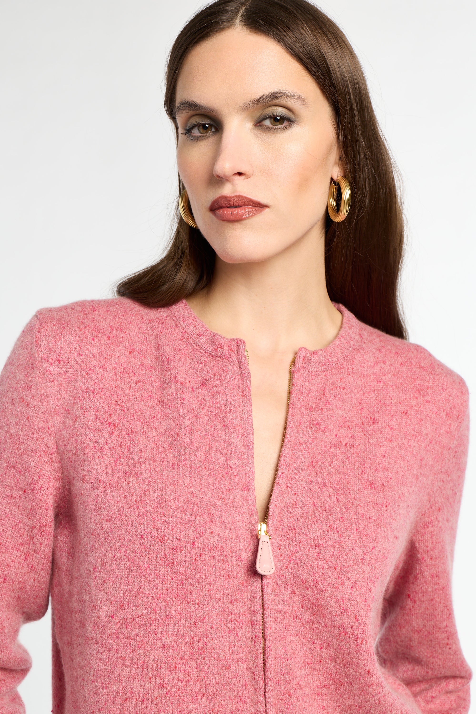 Woman wearing a pink textured jacket with a white background