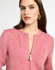 Woman wearing a pink textured jacket with a white background