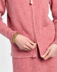 Close-up of a person wearing a pink textured outfit with a white background