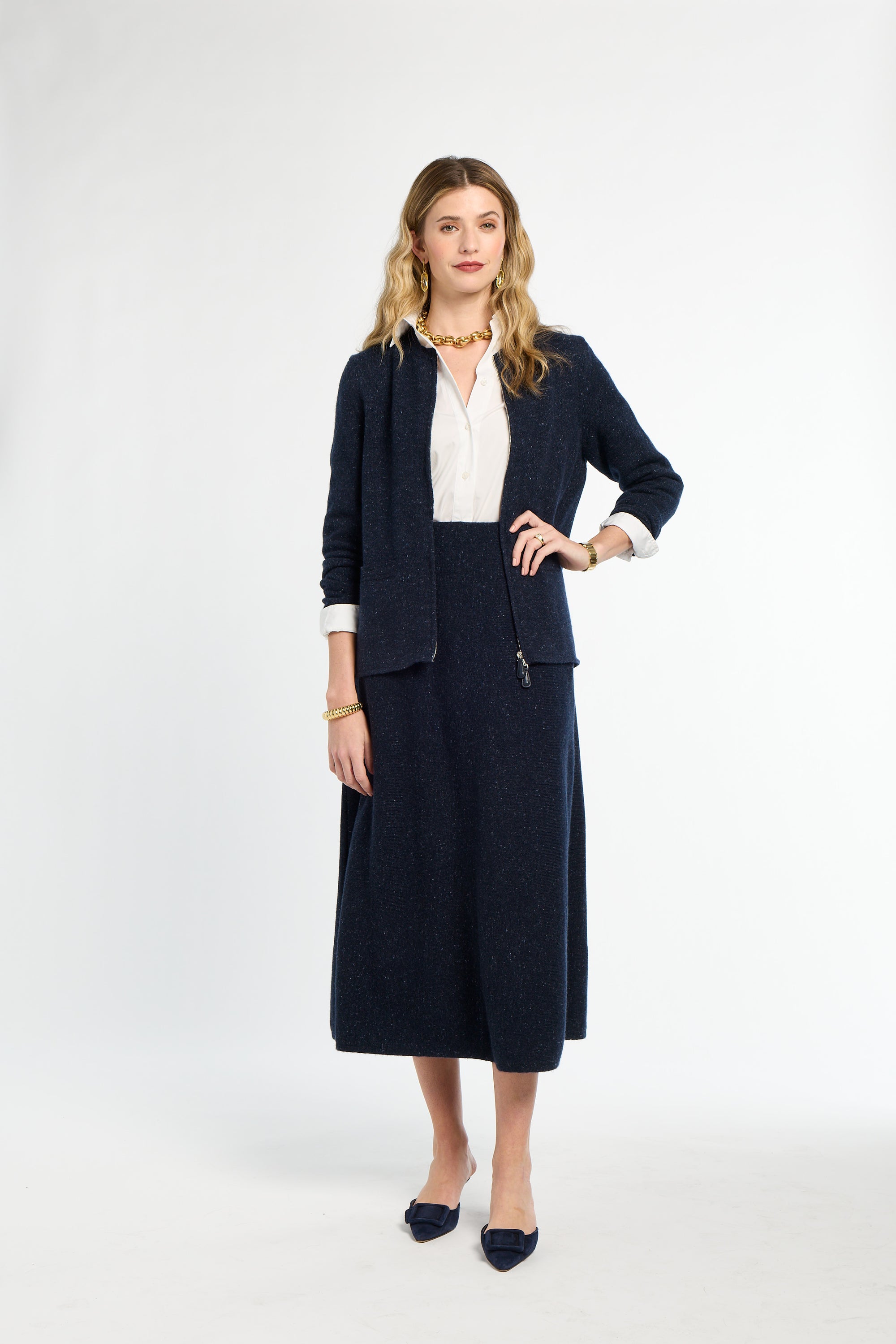 Woman wearing a navy suit with a white blouse on a white background