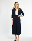 Woman wearing a navy suit with a white blouse on a white background