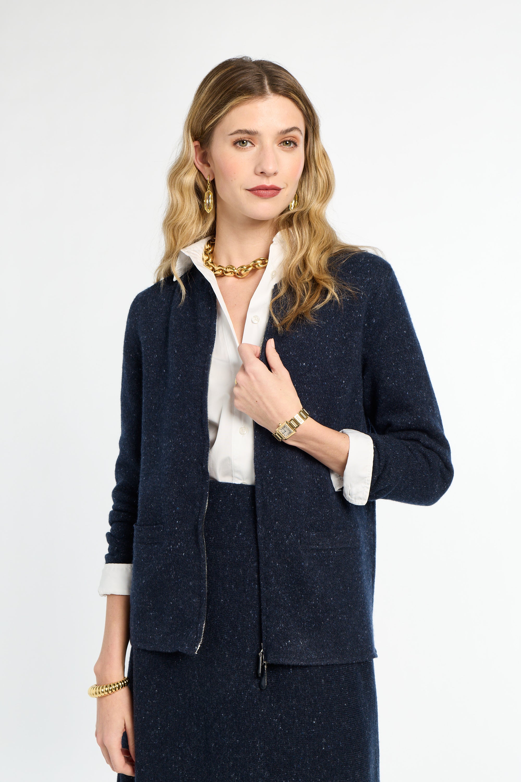 Woman wearing a navy blazer over a white shirt on a white background