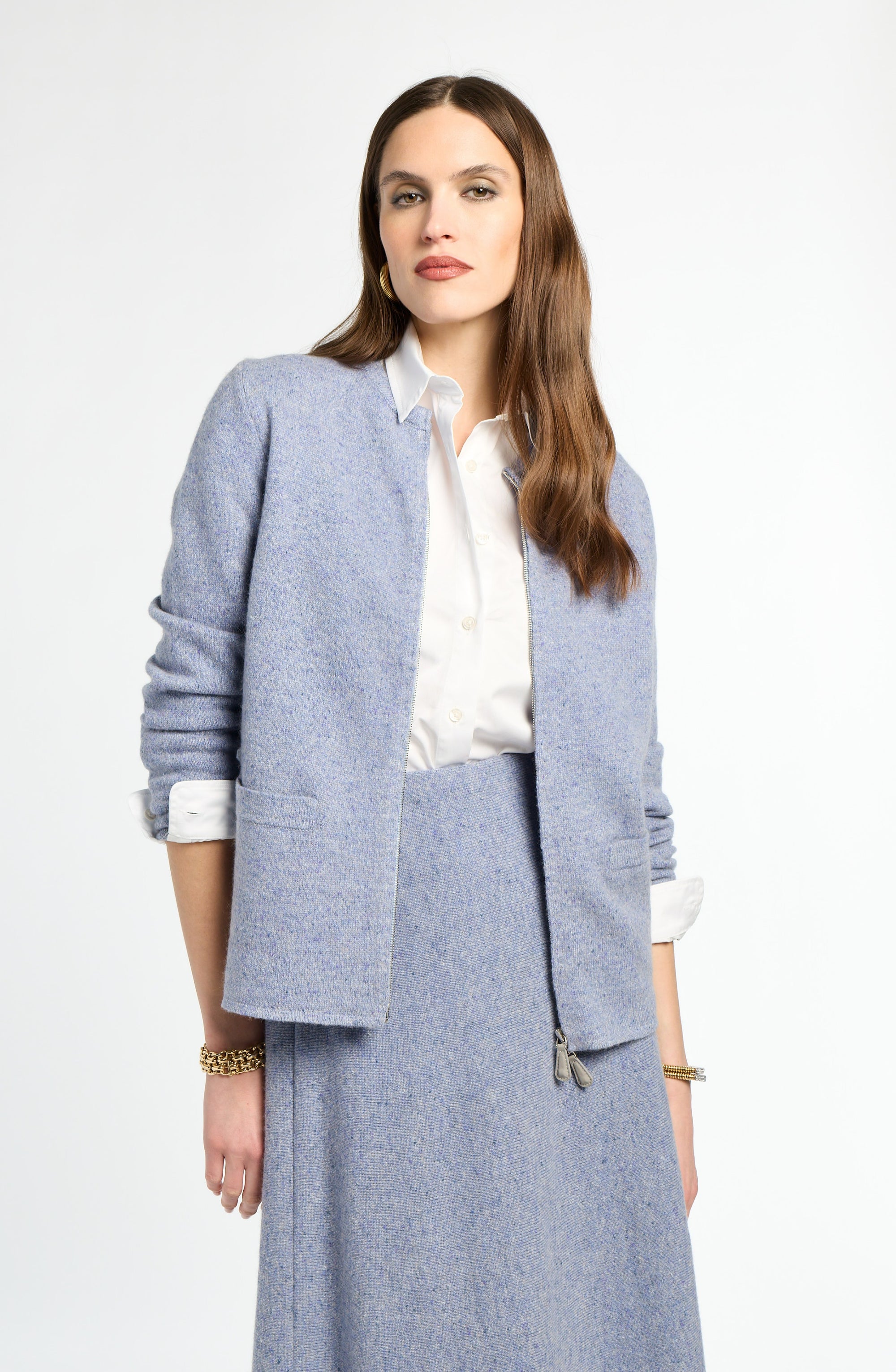 Woman wearing a light blue suit with a white shirt on a white background