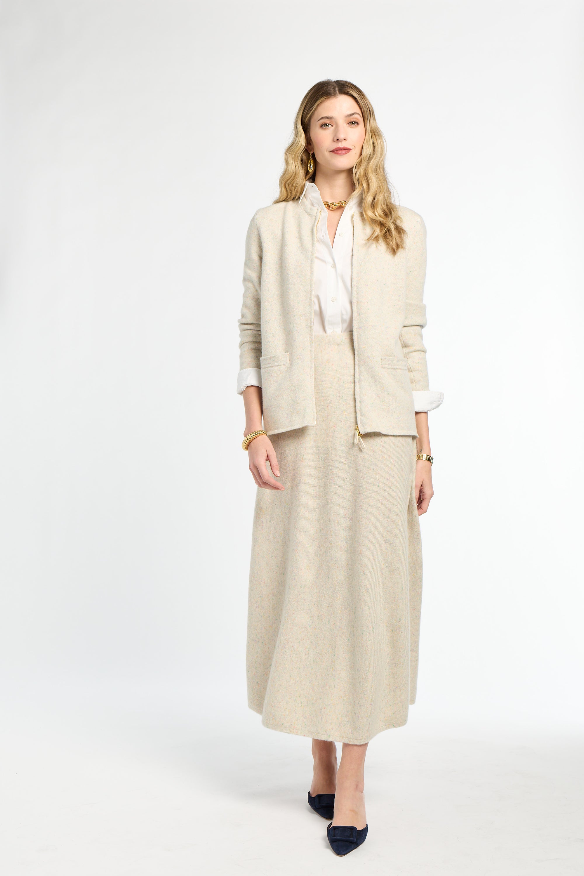 Woman wearing a beige suit with a white shirt on a white background