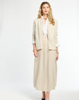 Woman wearing a beige suit with a white shirt on a white background