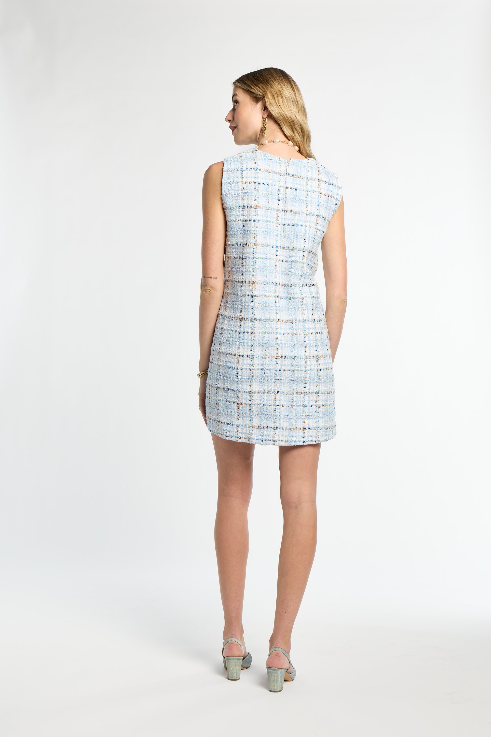 Woman wearing a light blue checkered dress on a white background