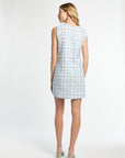 Woman wearing a light blue checkered dress on a white background