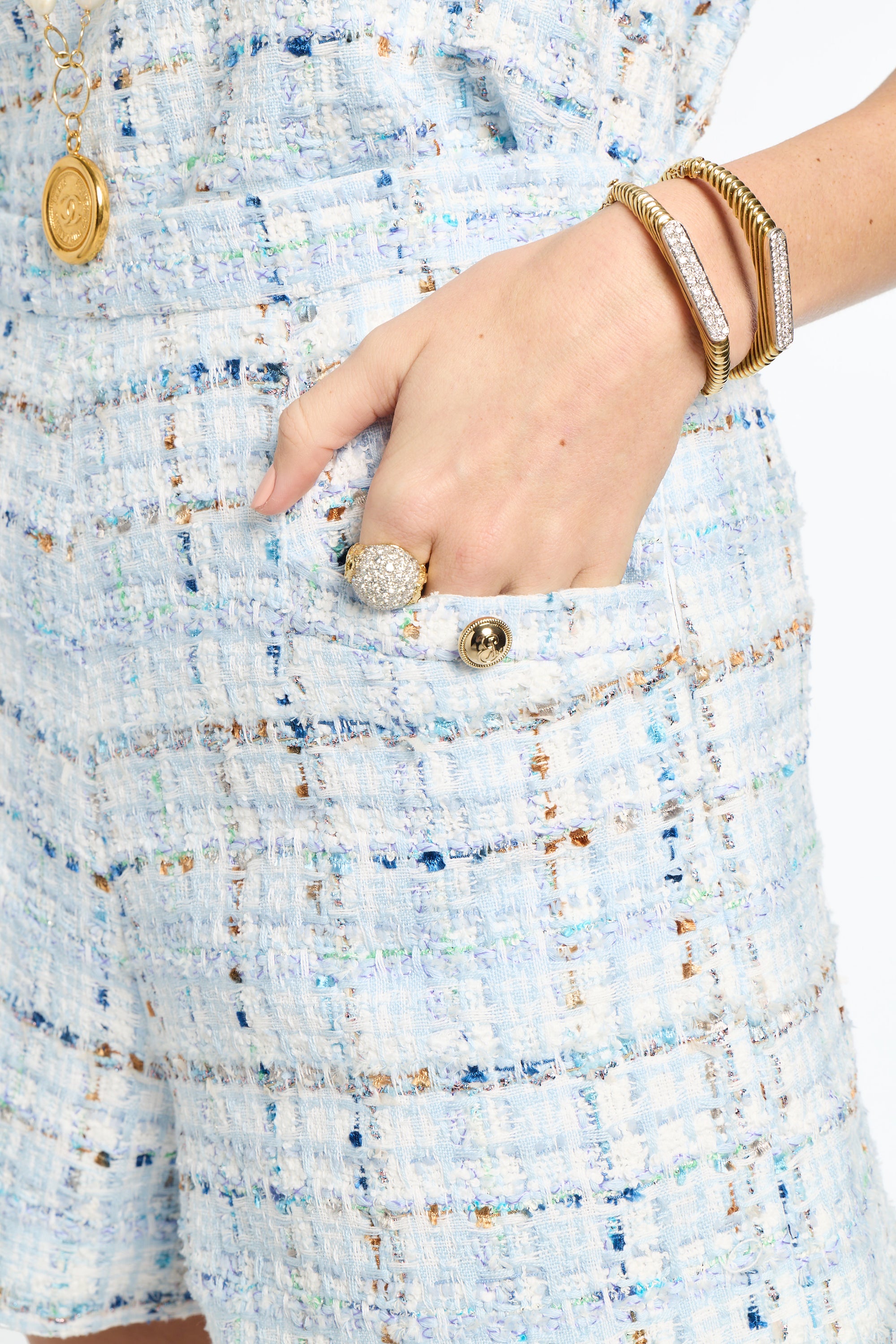 Close-up of a hand wearing a ring on a textured fabric background