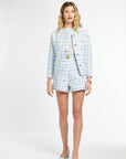 Woman wearing a light blue plaid suit on a white background