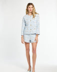 Woman wearing a light blue plaid outfit on a white background