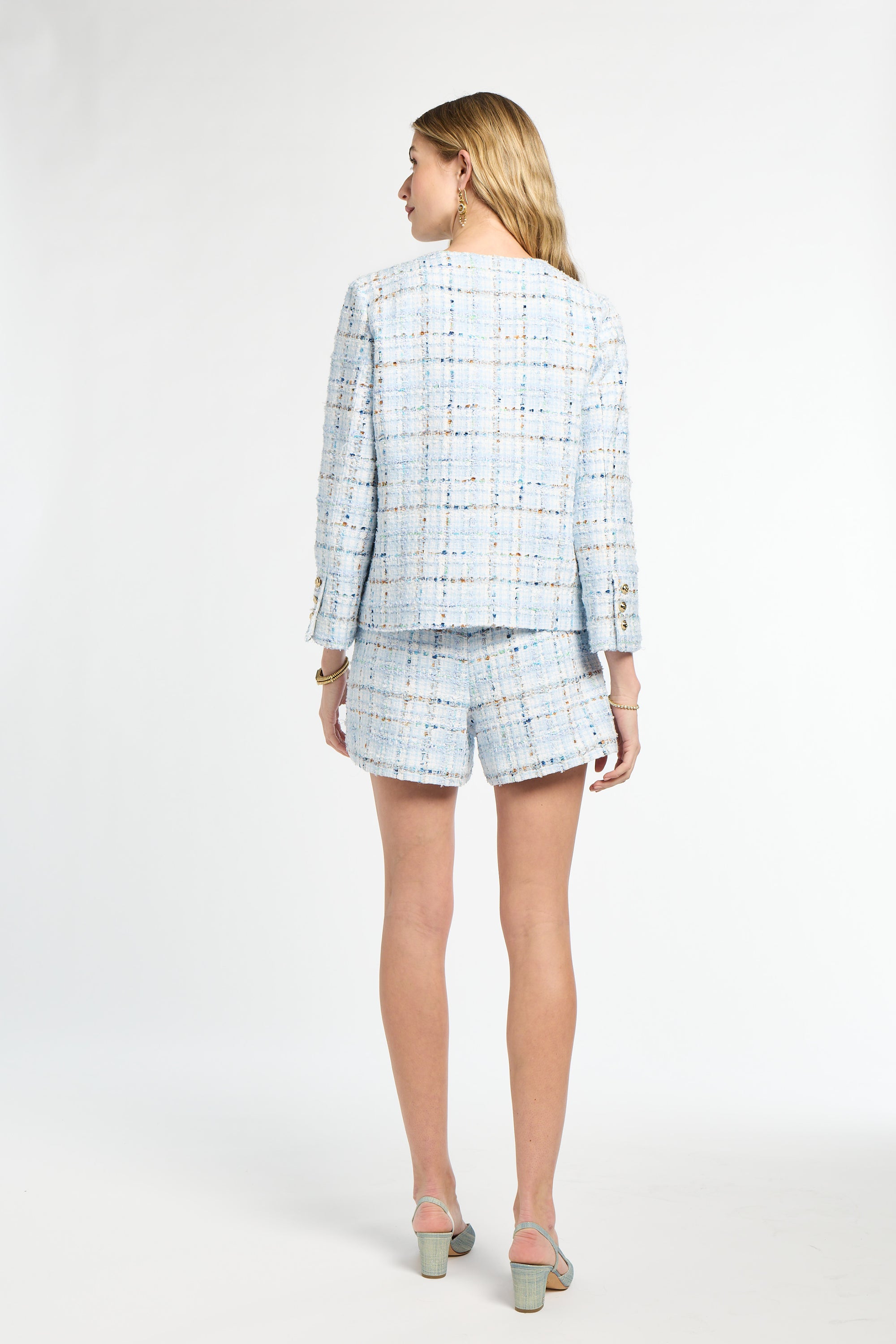 Woman wearing a light blue plaid suit on a white background