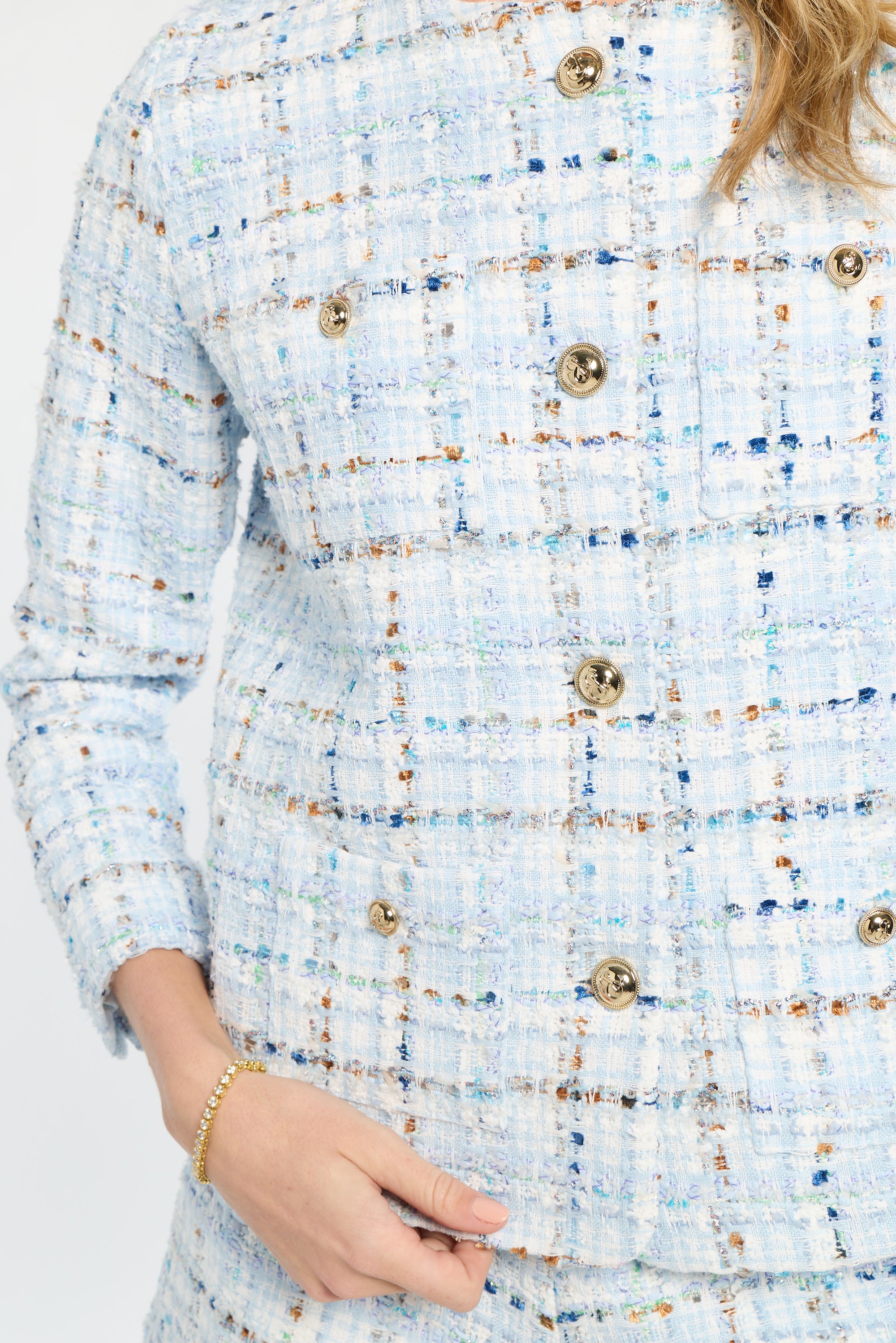 Close-up of a textured blue and white dress with gold buttons.