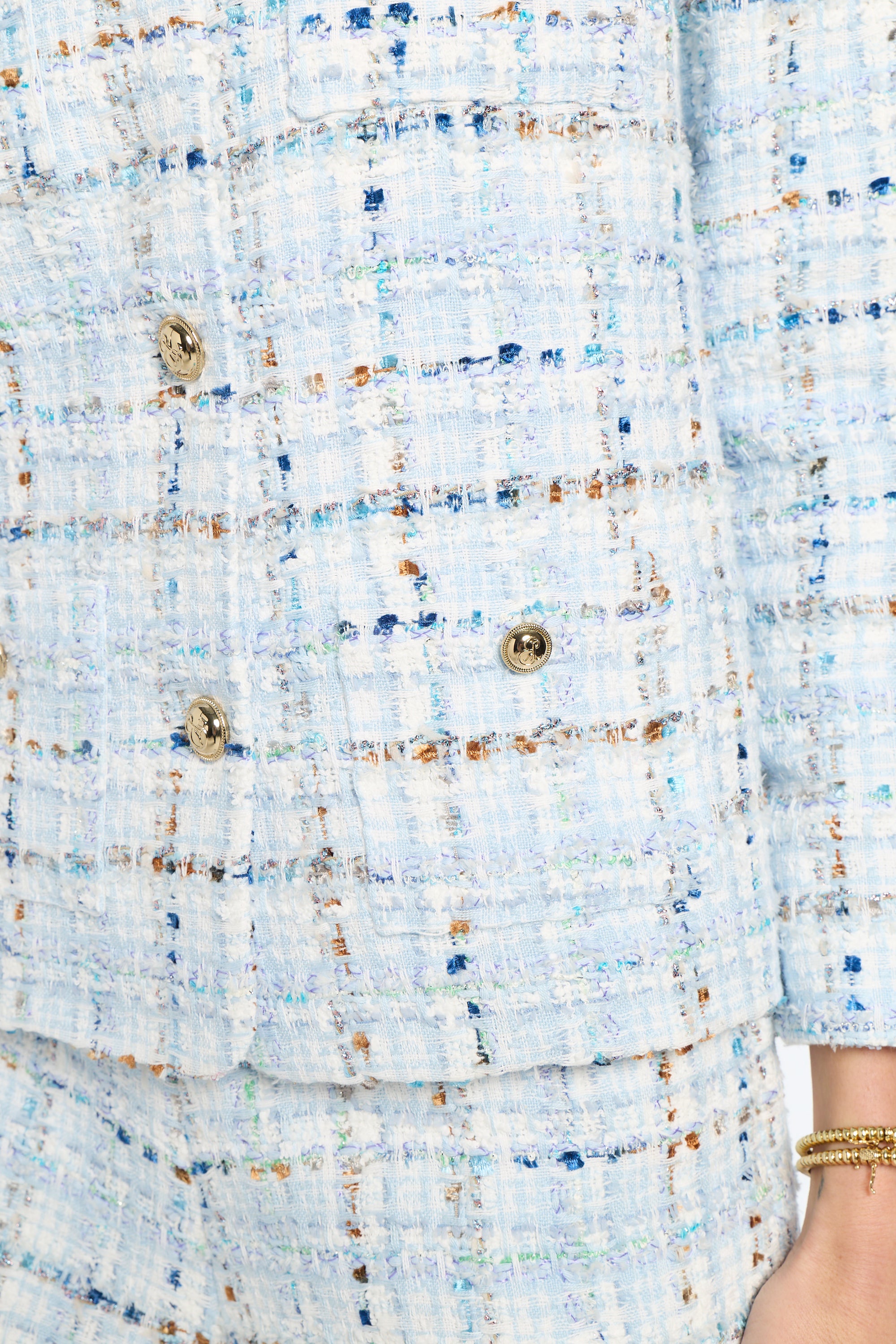 Close-up of a textured fabric with buttons on a light blue background