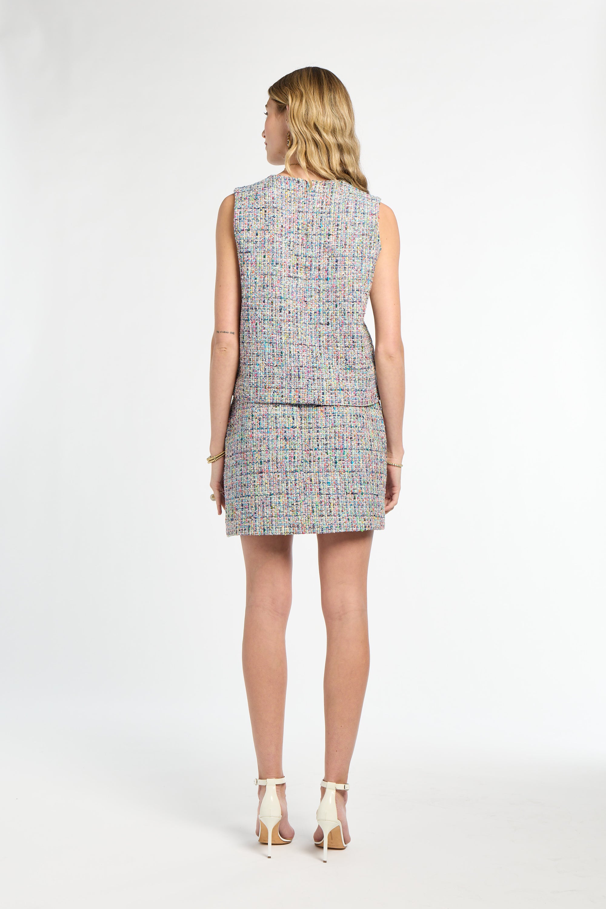 Woman wearing a sleeveless patterned dress on a white background