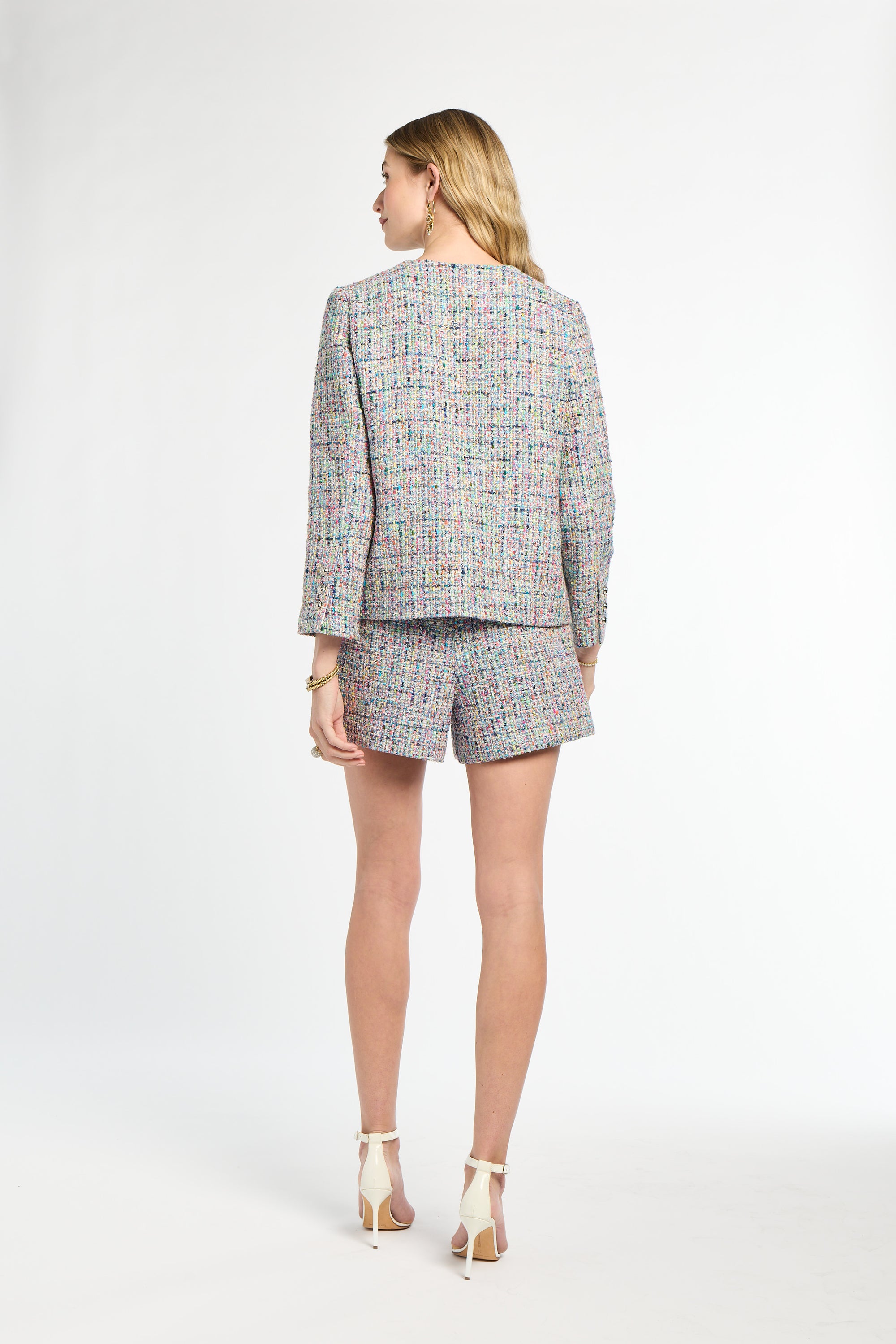 Woman wearing a patterned blazer and shorts set on a white background