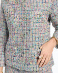 Multicolored textured outfit with a close-up of the fabric and a hand wearing a ring.