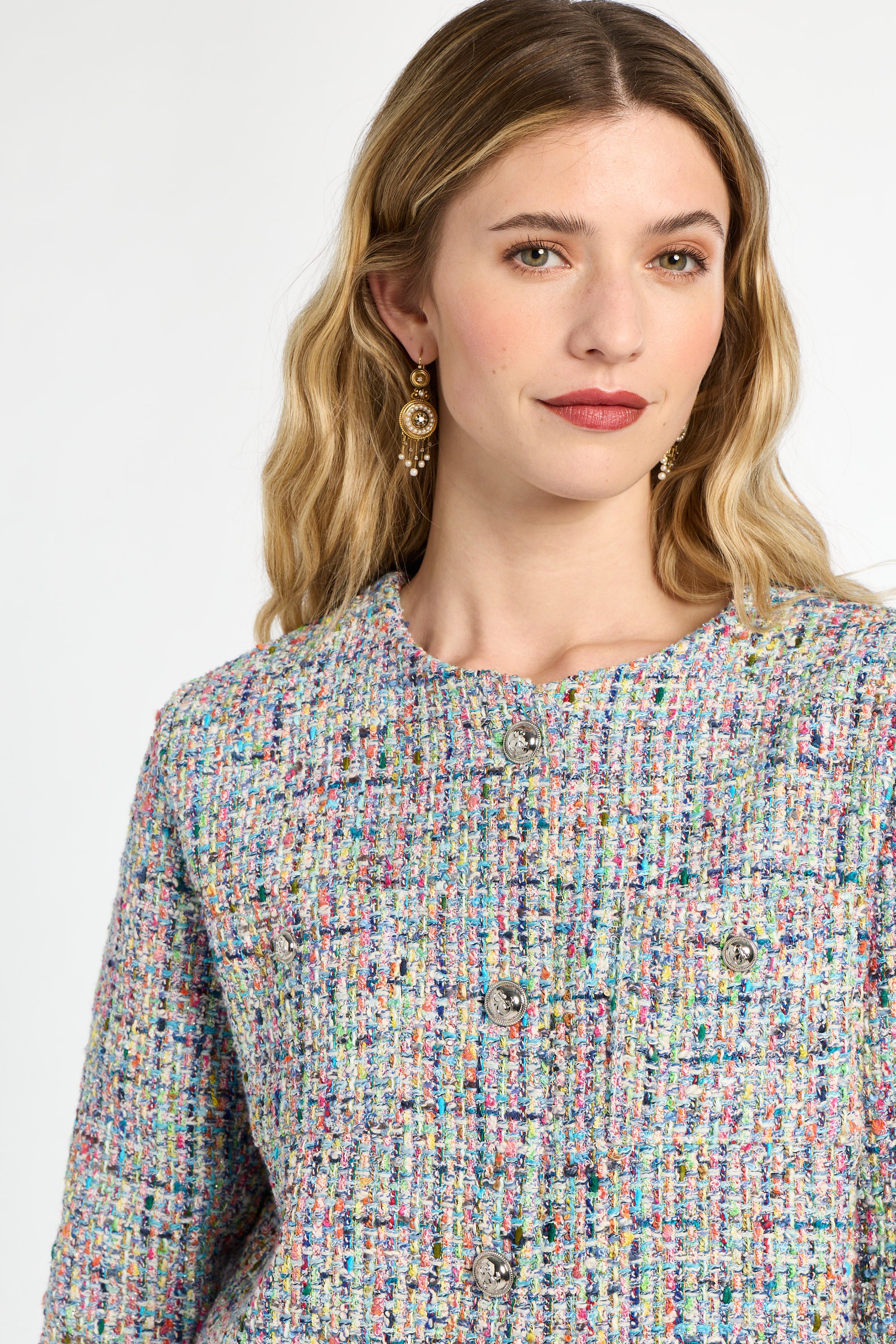 Woman wearing a multicolored textured top against a white background